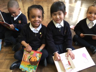 Smiling pupils with books St George's CE Primary
